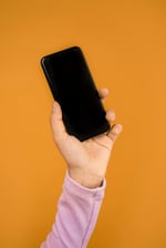 hand holding up a smart phone establishing communication methods